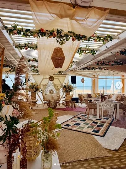 Décor bohème du lounge Sunset Beach avec voilages, pampa et vue mer.